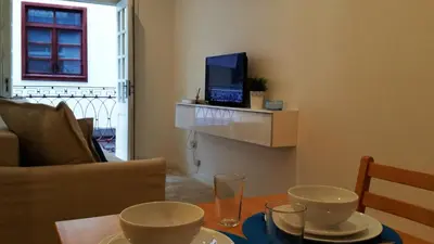 a living room with a table and a television on a wall at D&S - Crocodile House S. Bento Apartments in Porto