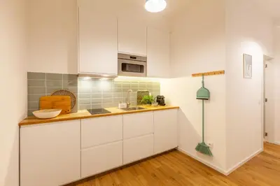 a kitchen with white cabinets and a wooden floor at D&S - Crocodile House S. Bento Apartments in Porto