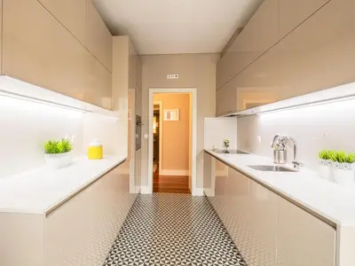 a kitchen with white counters and sinks and a hallway at Cardosas Boutique Apartment in Porto