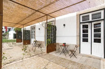 a patio with chairs and a table and a building at bnapartments Carregal in Porto