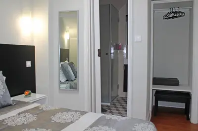a bedroom with a bed and a hallway with a mirror at Lunar Guest House in Porto
