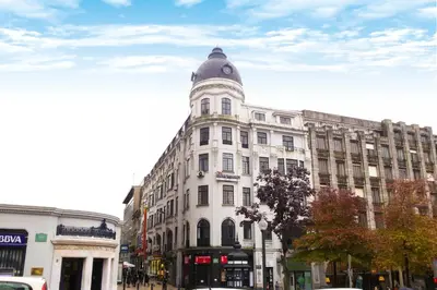 a white building with a clock on the top of it at Nice Way Porto Hostel in Porto