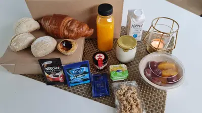 a table topped with a box of breakfast foods and orange juice at Go2Oporto - Historical Center in Porto
