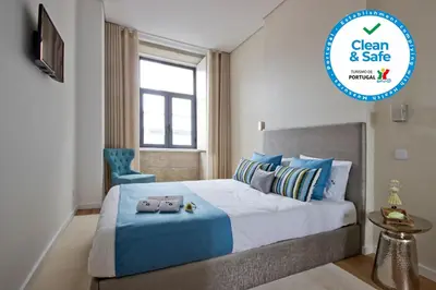 a bedroom with a blue and white bed and a window at OHH -Porto 4 you- Deluxe Apartment With Free Parking in Porto