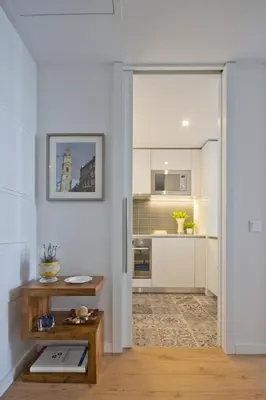 a kitchen with white walls and a door leading into a living room at OHH -Porto 4 you- Deluxe Apartment With Free Parking in Porto
