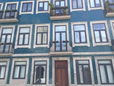 a blue building with white windows and a door at OHH -Porto 4 you- Deluxe Apartment With Free Parking in Porto
