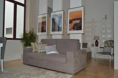 a living room with a couch and some pictures on the wall at Apartamento LM Ribeira in Porto