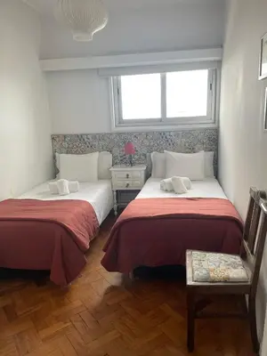 two beds in a small room with a window at Apartamento Vintage 2 in Porto