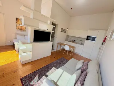 a living room with a white couch and a kitchen at Porto Cinema Apartments in Porto