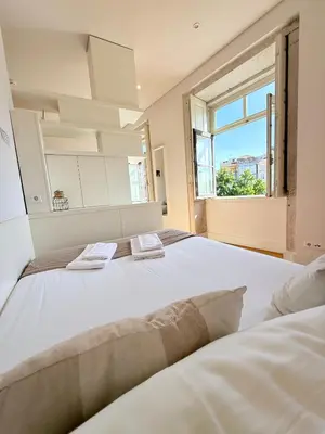 a large white bed in a room with a window at Porto Cinema Apartments in Porto