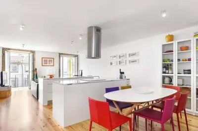 a kitchen with a table and red chairs in a kitchen at SBV Perfect River View in Porto