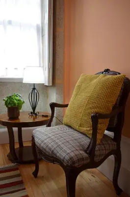 a chair with a pillow on it next to a table at Porto.arte guest apartments in Porto