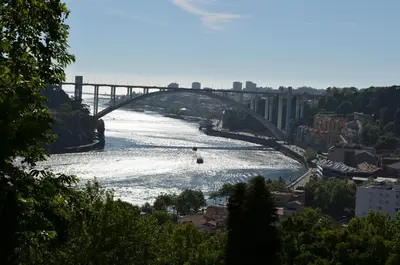a bridge over a river with a boat in it at Porto.arte guest apartments in Porto