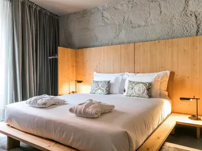 a bedroom with a large bed with two towels on it at Armazém Luxury Housing- Architectural & Design Hotel in Porto