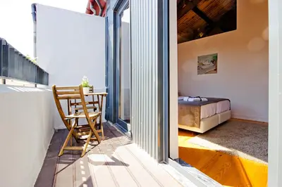 a room with a table and a chair on a balcony at MyStay Porto Bolhão in Porto