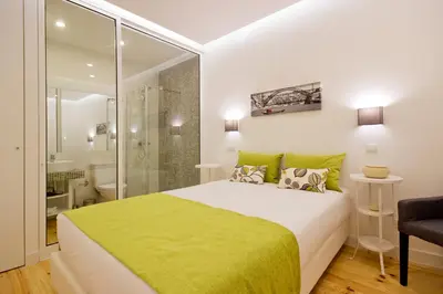 a bedroom with a white bed with an orange blanket at MyStay Porto Bolhão in Porto