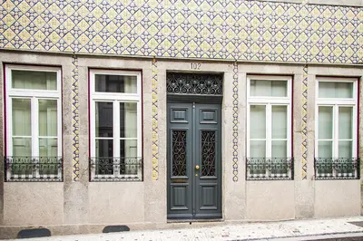 a building with a black door and three windows at Liiiving in Porto | Art & Heart Studio in Porto
