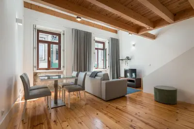 a living room with a couch and a table and chairs at BRA.com Apartments Oporto Pinheiros in Porto