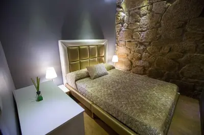 a bedroom with a bed and a stone wall at GuestReady - Eiffel Waterfront apartments in Porto