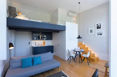 a living room with a blue couch and a table at Seventyset Flats - Porto Historical Center in Porto
