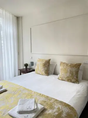 a bedroom with a white bed with towels on it at Impar Luxury Apartments in Porto
