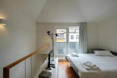 a bedroom with a bed and a large window at Impar Luxury Apartments in Porto