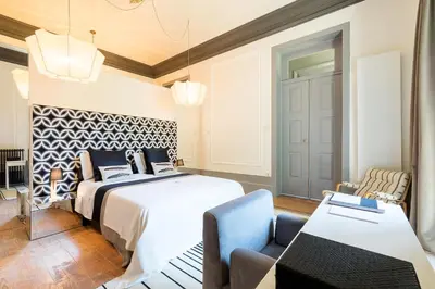 a bedroom with a bed and a couch and a table at Charm Palace Porto in Porto