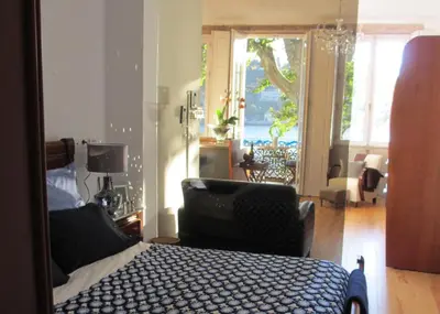 a bedroom with a bed and a chair and a window at Porto Douro River Guest House in Porto