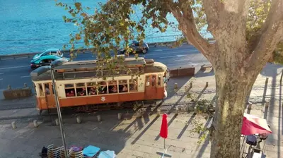 an orange trolley car on a street next to a tree at Porto Douro River Guest House in Porto