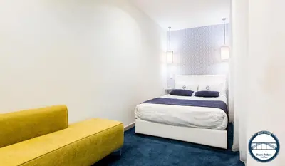 a bedroom with a bed and a yellow couch at Douro Riverside Apartments in Vila Nova de Gaia