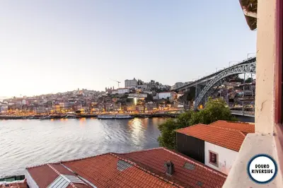 a view of a river with a bridge and buildings at Douro Riverside Apartments in Vila Nova de Gaia