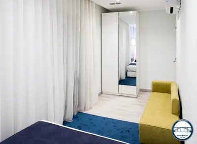 a bedroom with a yellow chair and a blue rug at Douro Riverside Apartments in Vila Nova de Gaia