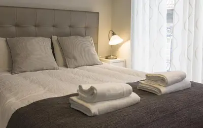 a bedroom with a bed with towels on it at D&S - Porto São Bento Apartments II in Porto