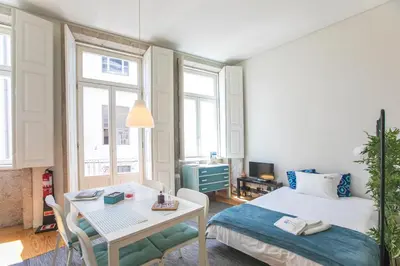 a bedroom with a bed and a table and a desk at Monchique´s Balcony in Porto