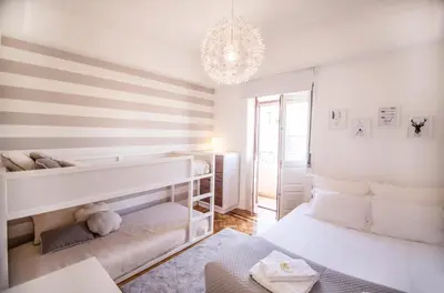 a white bedroom with a bunk bed and a chandelier at the5rooms.porto in Porto