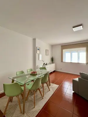 a dining room with a glass table and green chairs at Douro & Sea - River Side in Vila Nova de Gaia