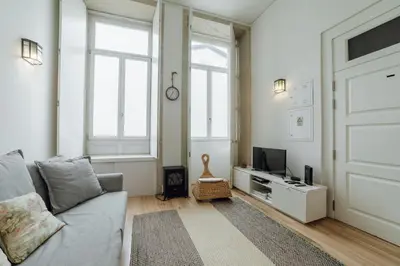 a living room with a couch and a tv at Historic & Sunny Mezzanine Bolhão by Vacationy in Porto