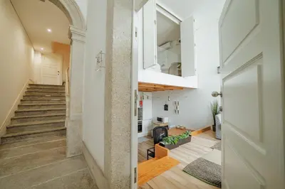 a hallway with a staircase and a door leading to a room with at Historic & Sunny Mezzanine Bolhão by Vacationy in Porto