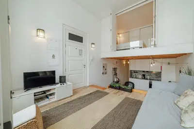 a living room with a couch and a tv at Historic & Sunny Mezzanine Bolhão by Vacationy in Porto