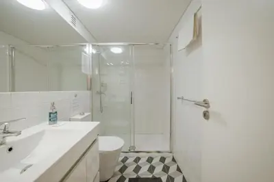 a bathroom with a shower and a toilet and a sink at Historic & Sunny Mezzanine Bolhão by Vacationy in Porto