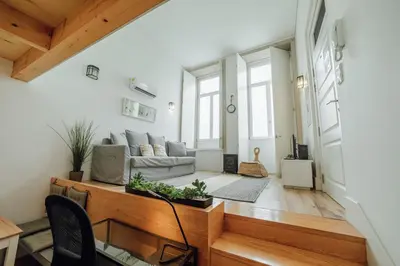 a living room with a couch and a table at Historic & Sunny Mezzanine Bolhão by Vacationy in Porto