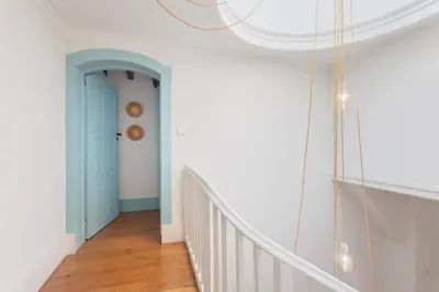 a hallway with a blue door and a staircase at Own Places Clérigos Apartments in Porto