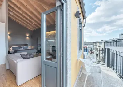 a balcony with a room with a bed and a window at Oporto Street Sá de Noronha in Porto