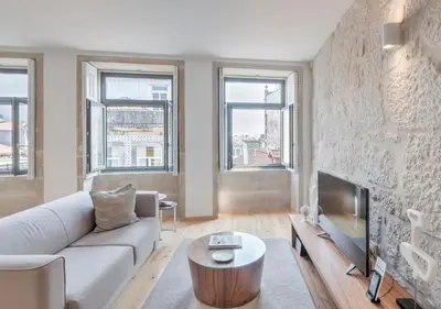 a living room with a couch and a tv at Oporto Street Sá de Noronha in Porto
