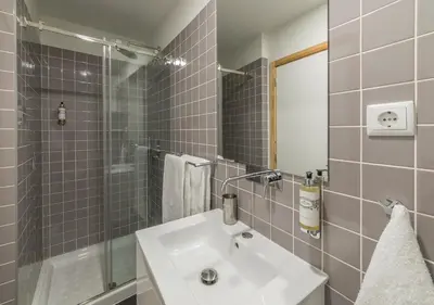 a bathroom with a sink and a shower and a mirror at Oporto Street Sá de Noronha in Porto
