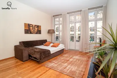 a bedroom with a bed and a large window at Locally Yours São Bento Apartments in Porto