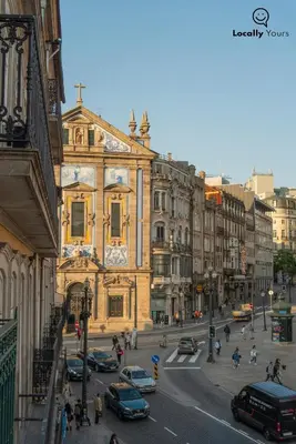 a city street with cars parked in front of a building at Locally Yours São Bento Apartments in Porto