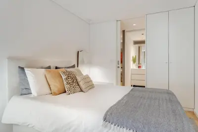 a white bedroom with a large white bed with pillows at Janika's Apartment in Porto
