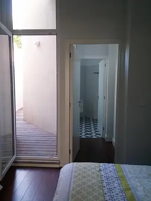 a bedroom with a sliding glass door leading to a bathroom at Oporto Downtown Apartment in Porto