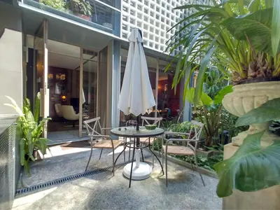 a patio with a table and a white umbrella at Garden House in Porto